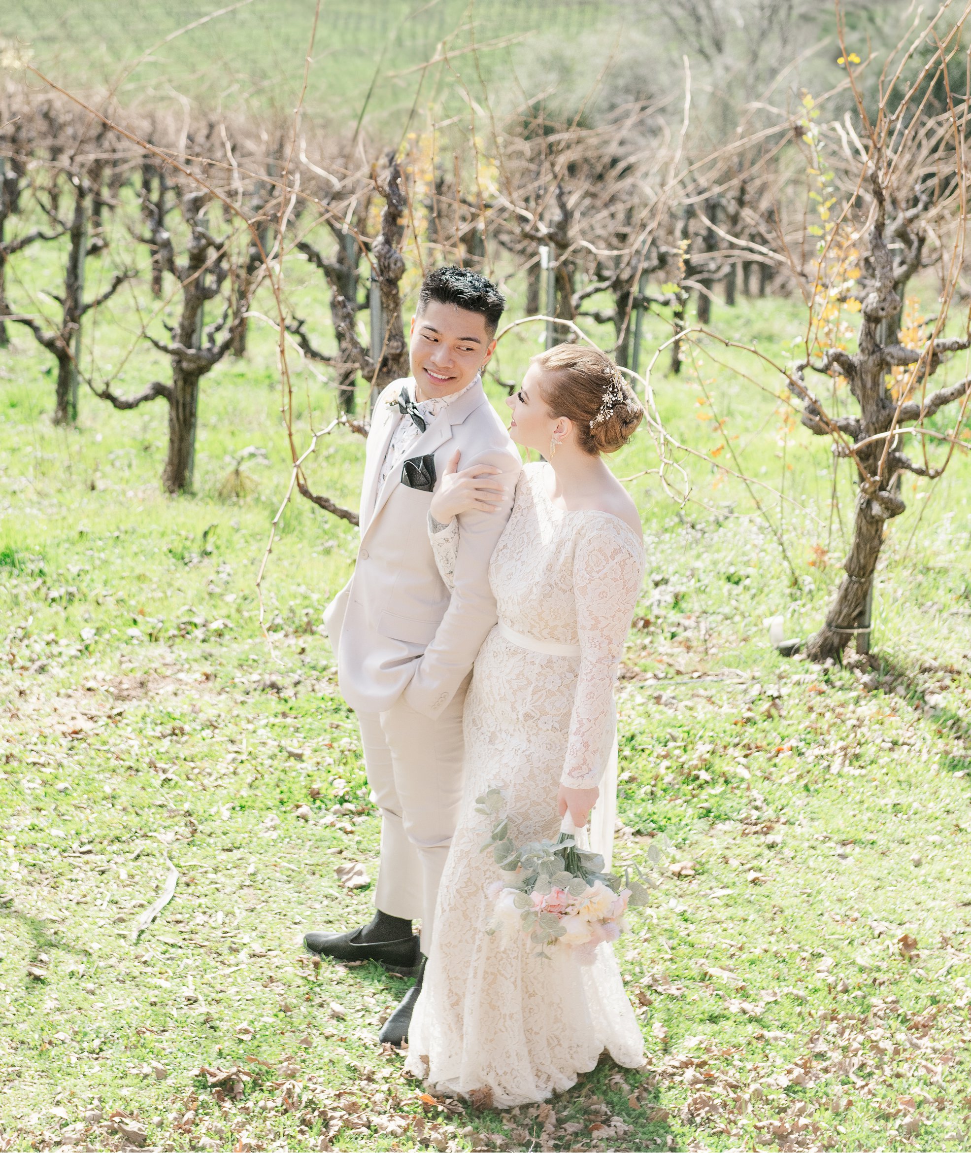 Bride & Groom smiling at each other in vineyard.